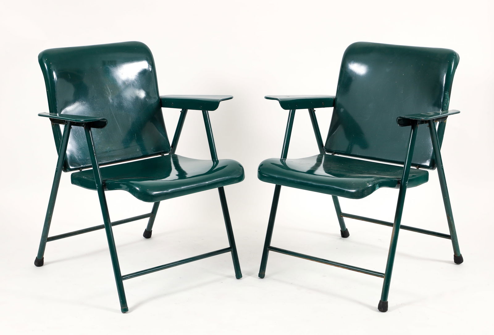 2 Russel Wright for Samson Green Metal Folding Chairs: Two Russel Wright for Sampson steel folding chairs refinished in a forest green lacquer, 1950s. Labels missing. 30.5 x 26 x 27 inches.