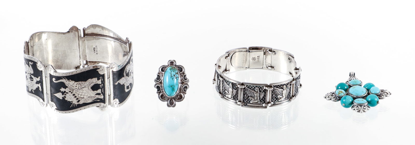 Assorted Silver Jewelry: Assorted silver jewelry includes silver link bracelets and turquoise and silver pendant and ring. The 2 silver bracelets include a Siamese bracelet with figural engraved links. Finished with a hidden