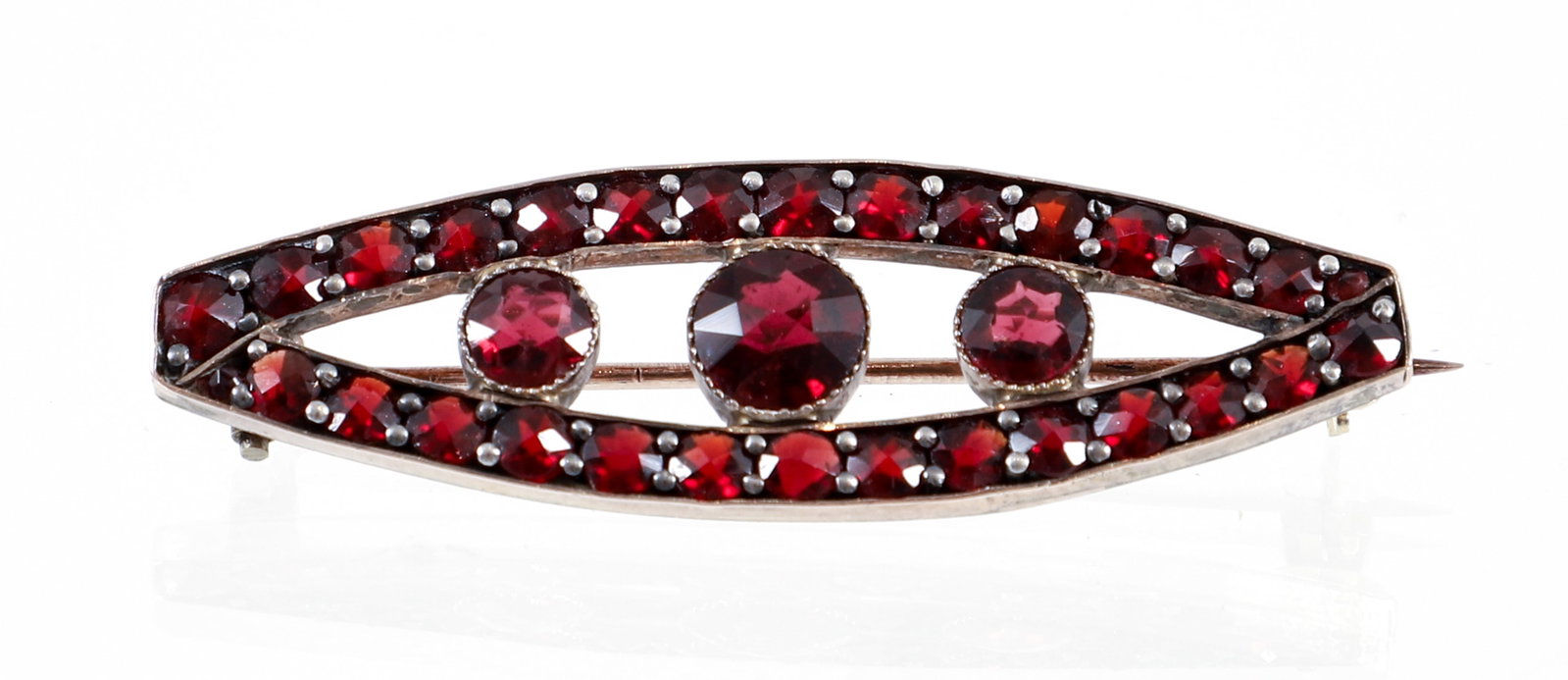Vintage Garnet Brooch: Vintage garnet brooch pin. The elongated marquise shaped pin features 3 bezel set round faceted garnets ( 2 - .34ct. ea., 1 - .51 ct). Surrounded by 28 round faceted garnets (.08 ct ea.). The pin meas