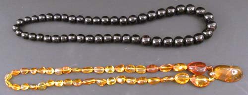 Strand Dom. Amber w lg pendant & Strand Black Cora: Title: Dominican Amber Necklace with Freeform stones and large pendant, along with strand of large round black coral beads Medium: amber, black coral Dimensions: 30 inches Provenance: Dr. Bernard and 