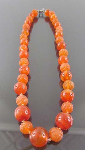 Carved agate bead necklace w/Chinese decoration: Title: Carved agate bead necklace w/Chinese decoration, sterling catch, carnelian color, mix of polished and carved beads Medium: carved agate Provenance: The Estate of Amelia Neville Shields Guirola 