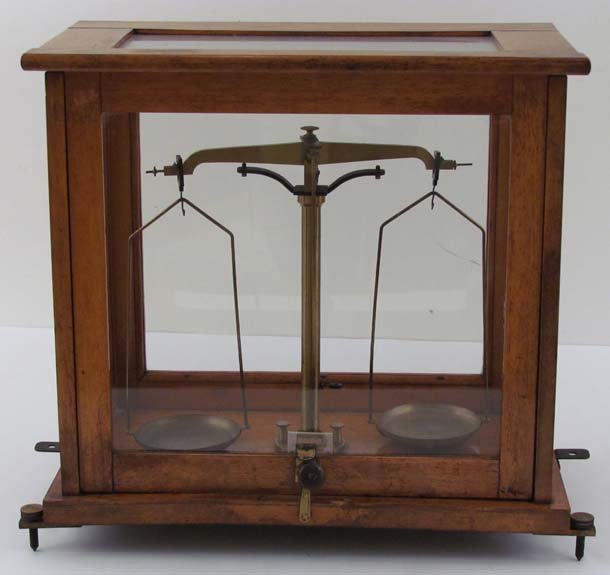 Cased Analytical Balance: Title: Cased Balance Analytical Balance Medium: wood, brass and other metals Dimensions: 15 x 18 x 9 inches Description: Pharmacy style balance beam scale with sliding glass door and knob adjusters, s