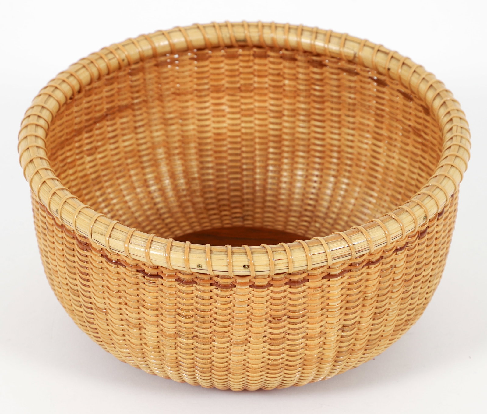 1989 Nantucket Basket: Nantucket Basket with center label 1989 mounted on wood base, 3.5 x 7.5 inches.