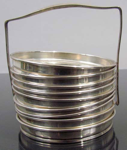 Sterling Coaster Caddy w 8 glass & sterling coasters: Title: Sterling Coaster Caddy w 8 glass & sterling rimmed coasters Medium: glass & Sterling Dimensions: coasters are 8 1/8 inch diameter Signature: stamped sterling on underside of each rim and bottom