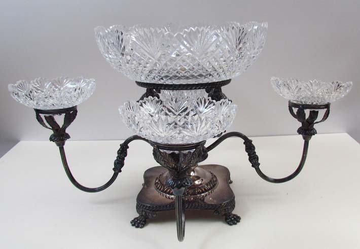 English silver plated and cut glass epergne: Artist: I. Freeman & Sons Title: English silver plated epergne with four reeded arms and claw feet Date: early 20th century Medium: silver plate and cut glass Dimensions: 11.75 x 21 x 21 inches <