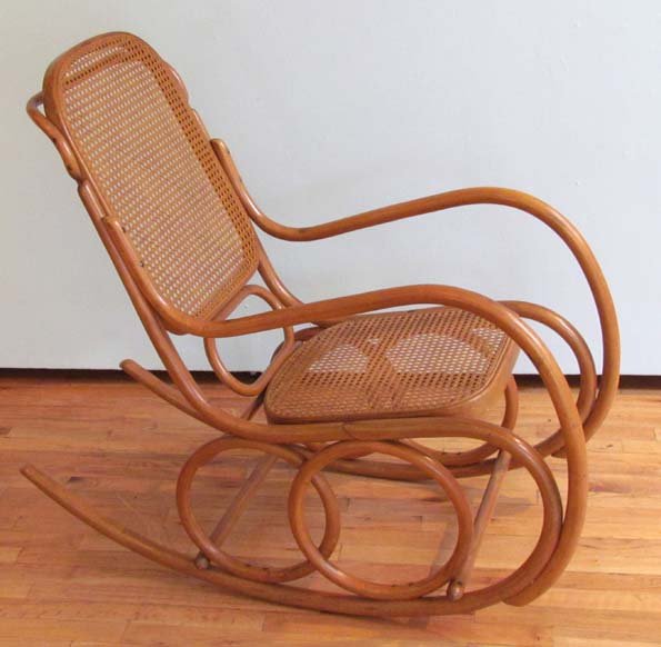 THONET STYLE BENTWOOD AND CANED ROCKING CHAIR: Title: THONET STYLE BENTWOOD AND CANED ROCKING CHAIR made in Czechoslovakia Medium: bent wood and caning Dimensions: 39 x 44 x 21 inches Provenance: The Estate of Morton Gurrentz