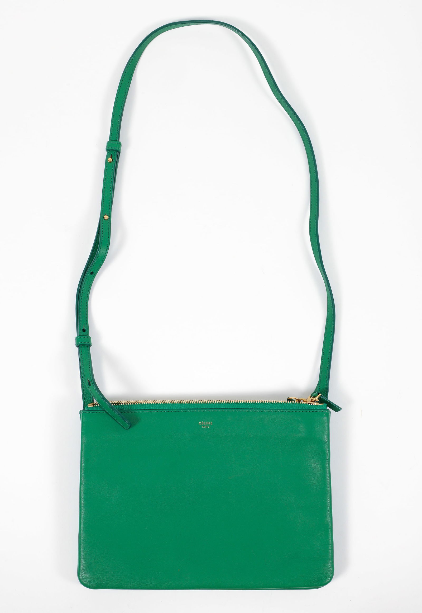 Celine Trio Crossbody Leather Bag in Kelly Green: Celine Trio crossbody leather bag in kelly green. Detachable outer sections snap on and off. Each section with zippers opening to grey fabric lined interiors. With gold tone hardware. Adjustable strap