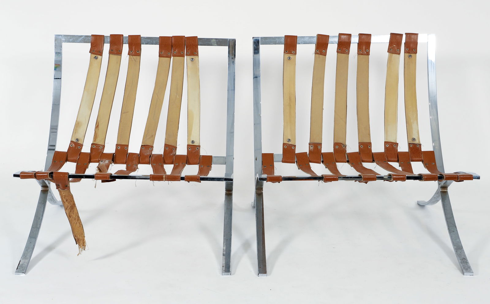 Pair of Barcelona Style Lounge Chair Frames: A pair of Barcelona style chairs after the iconic Mies Van der Rohe design, mid 20th century. Brown leather straps on polished steel frames. Apparently unmarked. Approximately 29.75 x 29.5 x 30.25