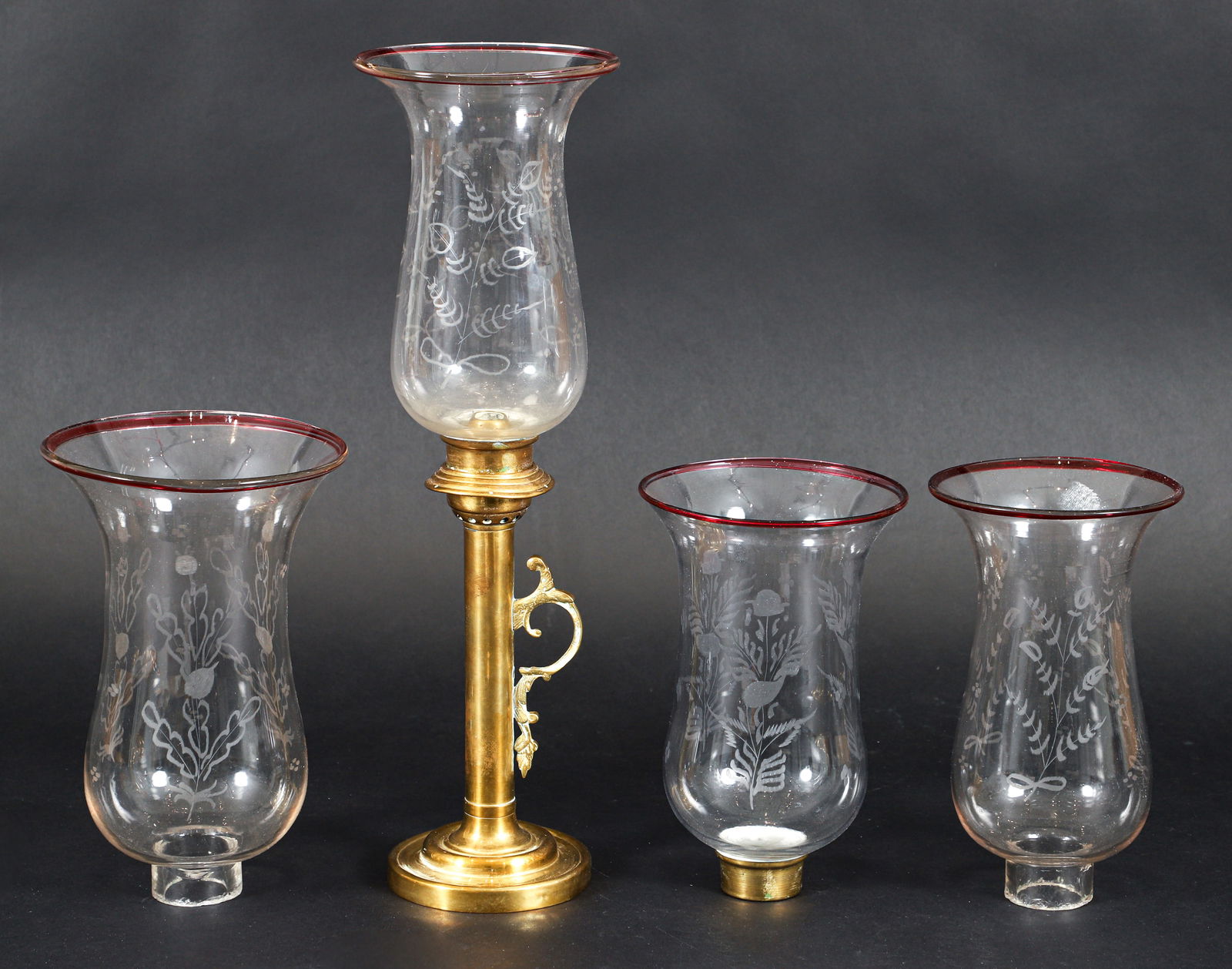 Four Hand Blown Hurricane Shades with Brass Candlestick: Four hand blown hurricane shades together with a brass candlestick. Shades with cranberry rims and etched sides. 3 shades approximately 9.5 inches in height, 1 shade 105 inches in neight, candlestick