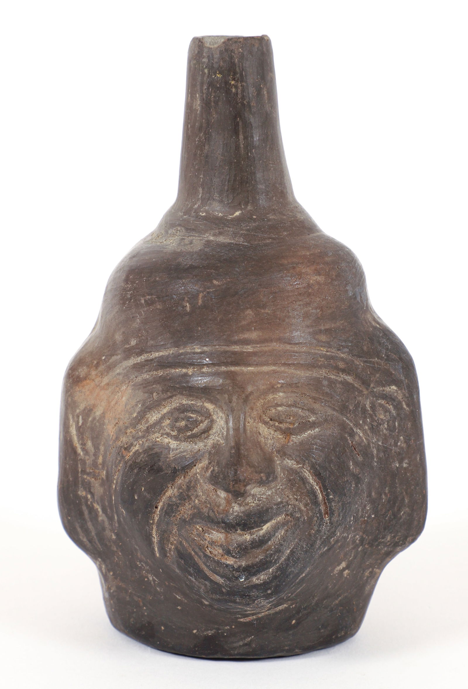 Moche Blackware Pottery Face Vase: Pre-Columbian, North Coast of Peru, Moche, ca. 300 to 700 CE. A hand-built blackware pottery vessel depicting the face of a male on the front with a top spout. 6 inches tall,