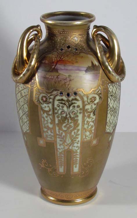 Classically Decorated Hand painted Nippon Urn: Artist: Nippon Title: Urn with Landscape Reserves of Sunsets, Arabesque Decoration Medium: porcelain Dimensions: 15.5 inches tall Signature: Stamped Hand Painted Nippon on underside
