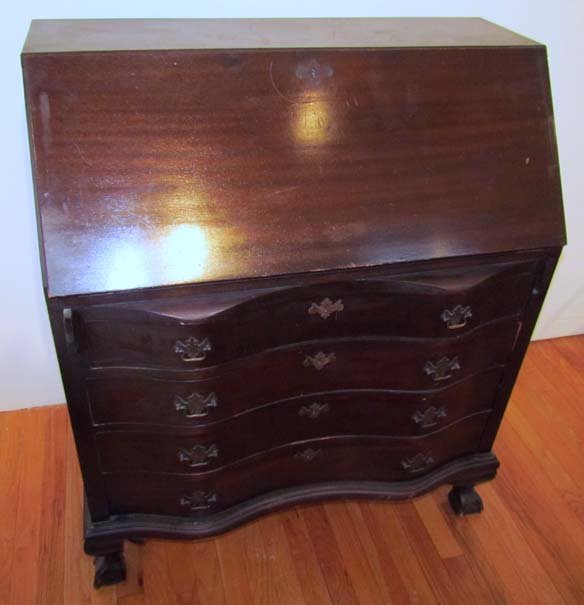 Serpentine front slant front desk: Title: Serpentine front slant front desk with fitted serpentine shaped interior compartment and ball and claw feet; desk over 4 serpentine shaped drawers Medium: walnut with a mahogany finish Dimensio