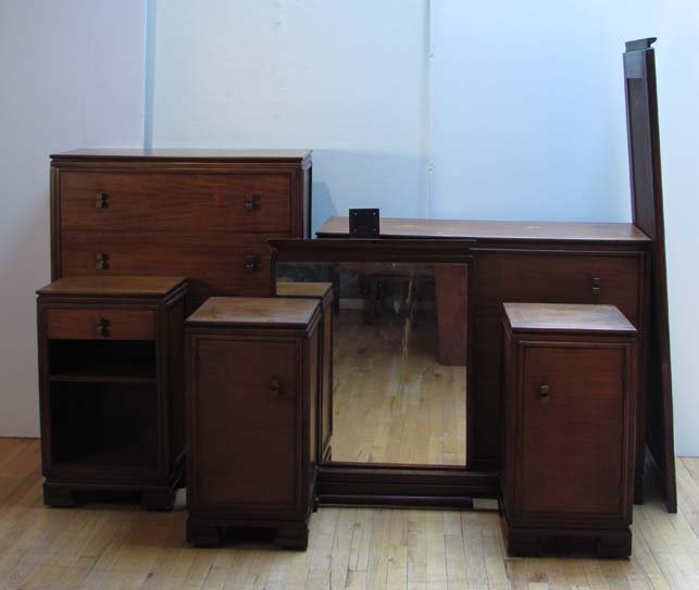 Donald Deskey for Amodec Bedroom Set: Artist: Deskey, Donald for Amodec Title: Bedroom Set featuring 2 dressers, mirror, vanity, and nightstand with bronze pulls, on casters Medium: wood with bronze hardware Signature: Amodec labels
