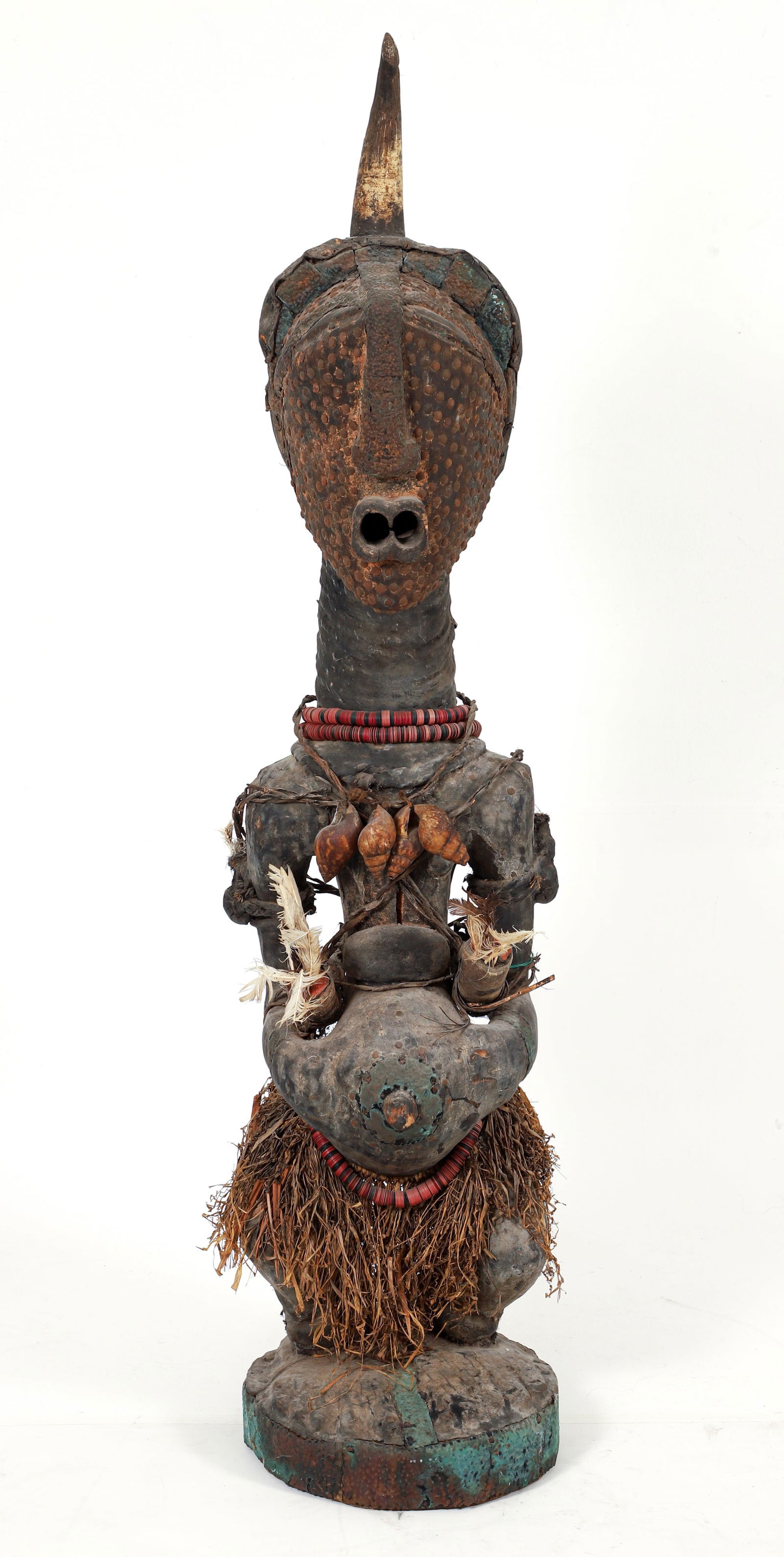 Songye Nkisi Power Figure: Nkisi power figure, Songye peoples (or after), Democratic Republic of the Congo. Carved wood figure with tacks covering face/head, copper attachments, snail shell necklace, magic-filled horns held in