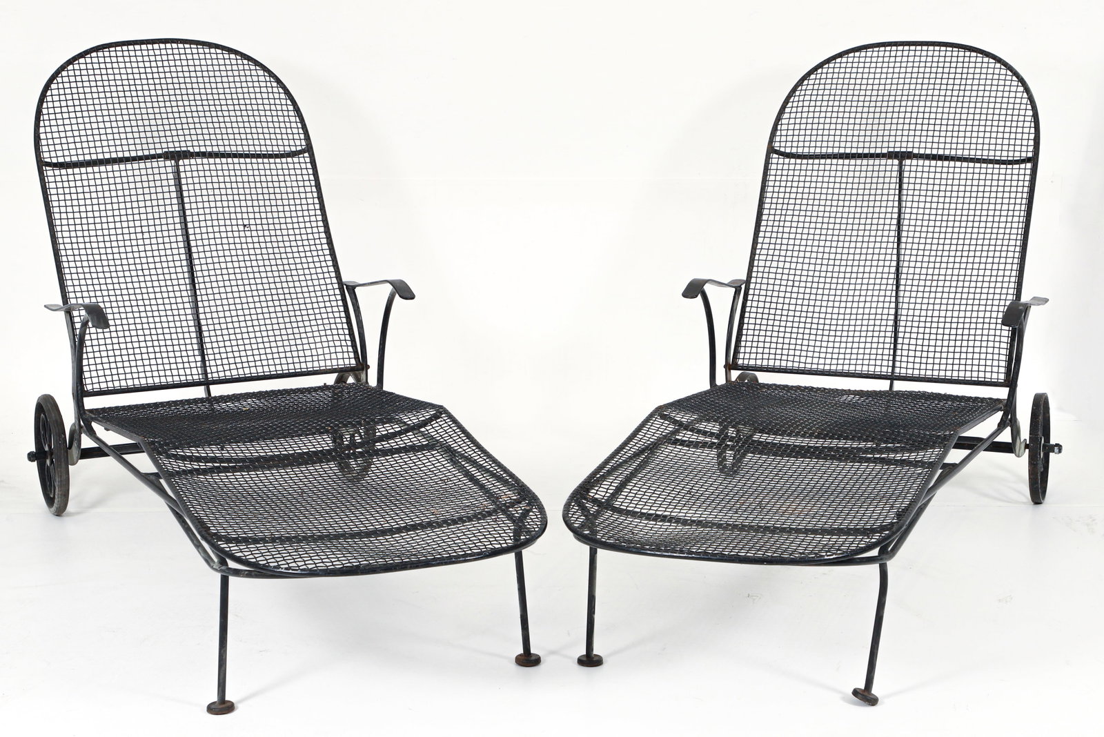 Pair of Russell Woodard Sculptura Chaise Lounges: Pair of Russell Woodard Sculptura chaise lounges, American, 1950s/1960s. Steel enameled in black. Resting on two wheels with flower motif, and two legs with pad feet. Both 34 x 25.25 x 66 inches.