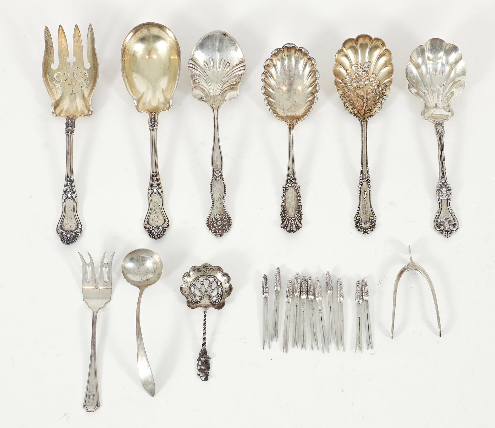 Group of 22 Sterling Silver Serving Pieces: Group of 22 sterling silver serving pieces. 12 corn on the cob forks, 1 small ladle, 1 serving fork, 4 serving spoons, 1 small pierced bon bon server, Pair of parcel gilt salad serving pieces (spoon a