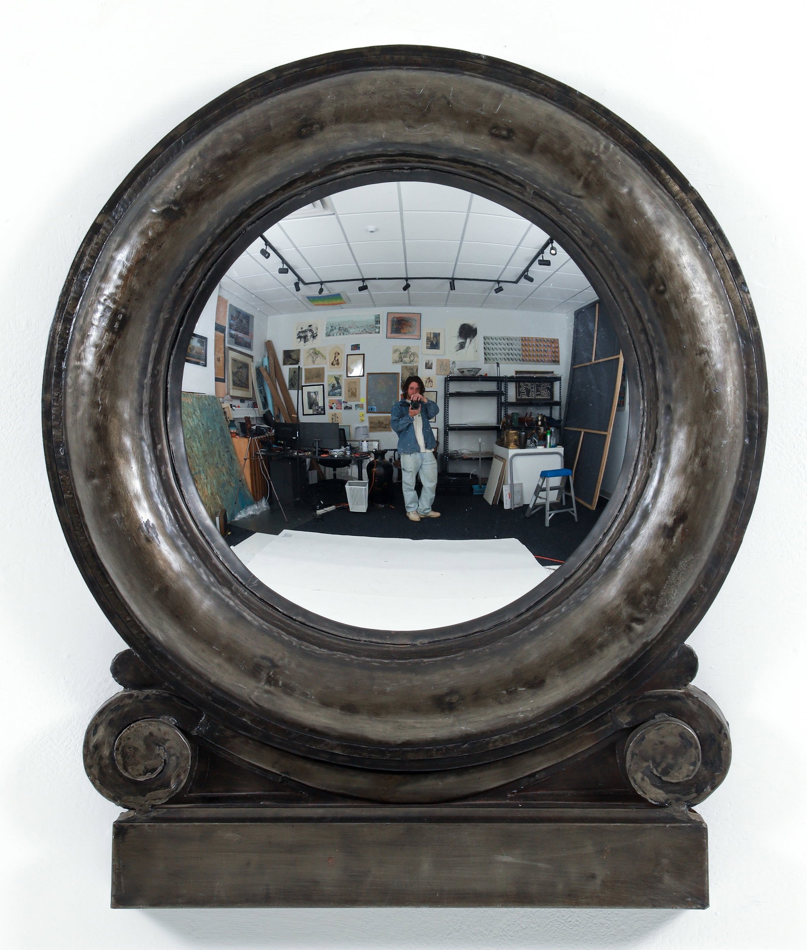 Oeil de Boeuf Pauillac Mis en Demeure Mirror: Oeil de Boeuf Pauillac Mis en Demeure Mirror, French, contemporary. Circular steel frame surrounding inset convex mirror over scrolling elements and base. Approximately 42 x 32 inches.