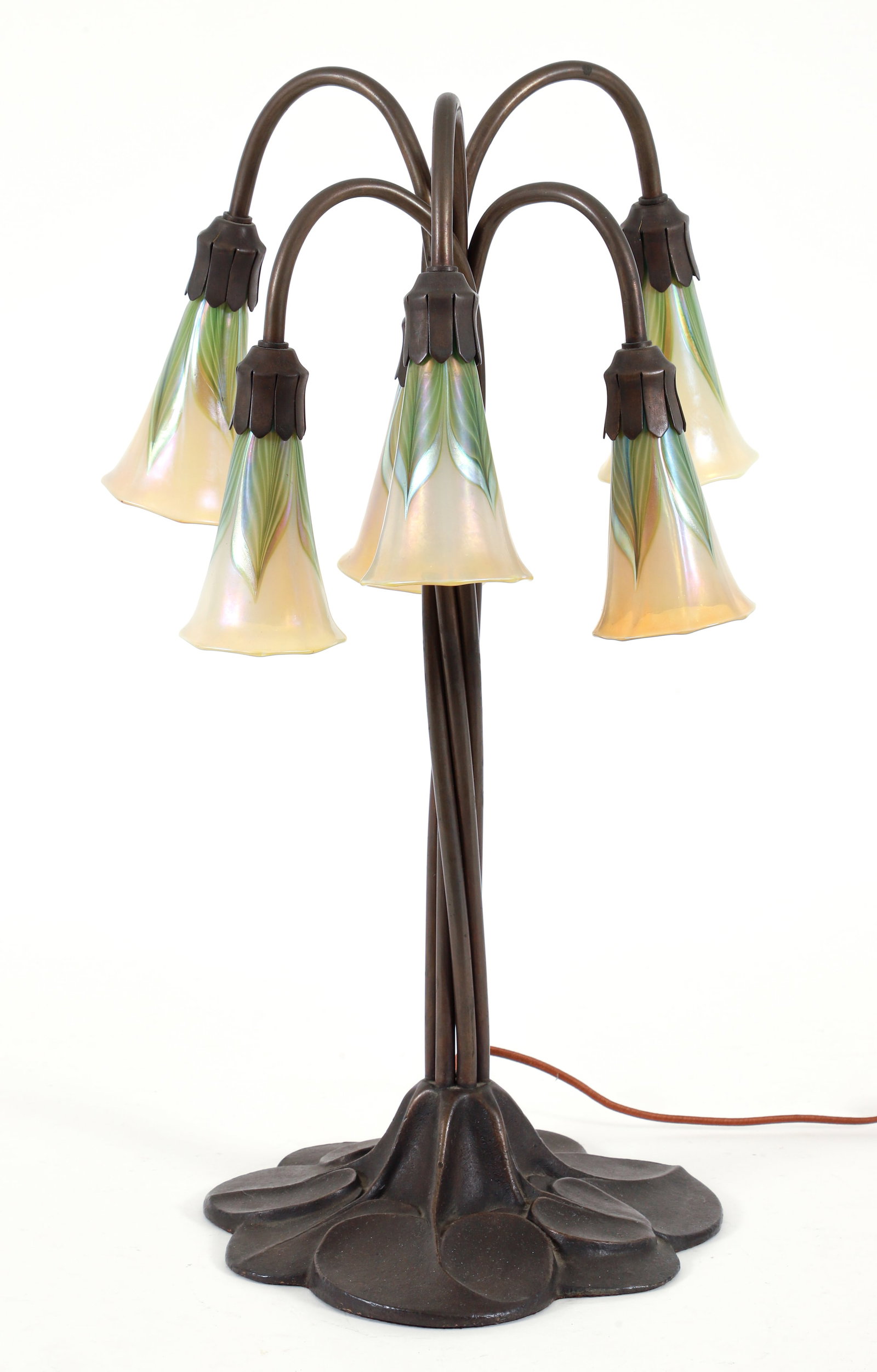 Tiffany Style Lily Table Lamp: Tiffany Style lily table lamp, 20th century. Of good quality, with lily pad molded circular base issuing twelve twisted stems, each terminating in a white and green art glass floriform shade. Apparent