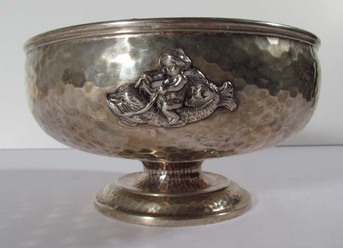 DUHME & CO. Hand hammered sterling bowl with figures in: Artist: DUHME & CO Title: Hand Hammered bowl with three relief figures, Cherub riding a fish, a Cockatoo, and fish Date: 19th Century Medium: hand hammered sterling bowl Dimensions: 4.5 x 8.5 x 8.5