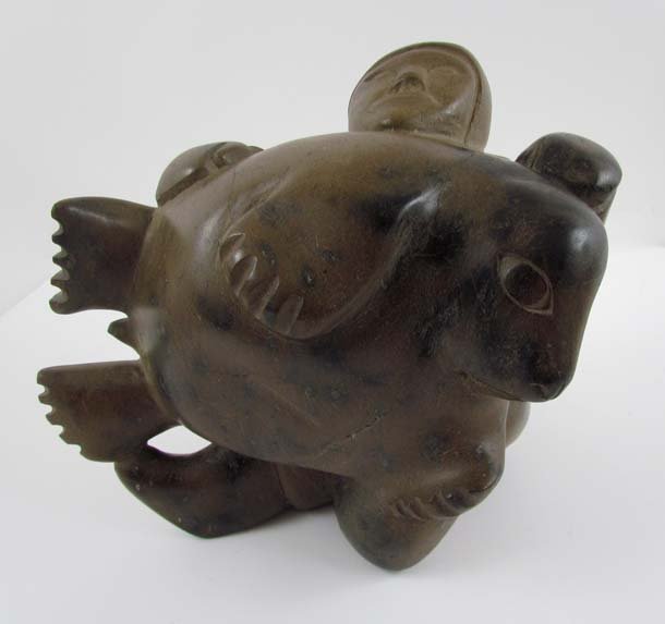 Inuit Sculpture of Hunter Holding a Seal: Artist: (20th Century Inuit School) Title: Inuit Hunter Holding Seal Dimensions: 10.5 x 13 x 9 inches Signature: signed on underside in Inuit Provenance: The Estate of Phylis and Erwin Kalla sold to