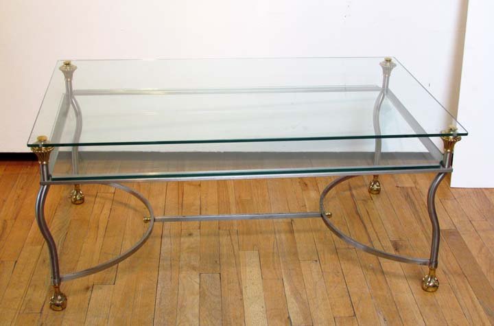 Double Tier glass brass steel coffee table: Double Tier glass brass steel coffee table with brass cast ball and claw feet; 18.75 x 41.75 x 25.5 inches; Provenance: Gil Walsh Design
