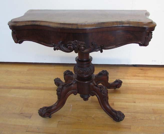 Early Victorian Fold Top Games Table: Title: Early Victorian Fold Top Games Ox Bow Front Table with fine burled walnut veneer resting on boldly carved pedestal Dimensions: 29 x 36.5 x (35 inches square when open Provenance: An Oakland Est