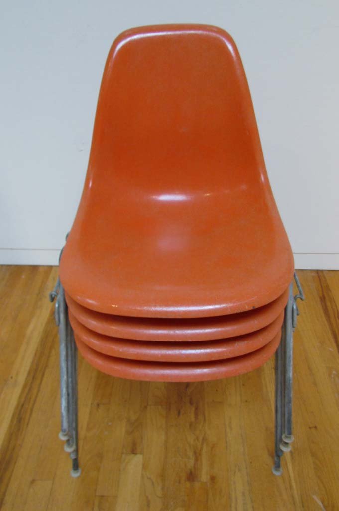 Four Eames Orange Stacking Shell Chairs: Artist: Eames, Charles and Rae Title: 4 Orange Stacking Shell Chairs Medium: fiberglass Dimensions: 31.75 x 23.25 x 18.5 inches Signature: white labels undersides