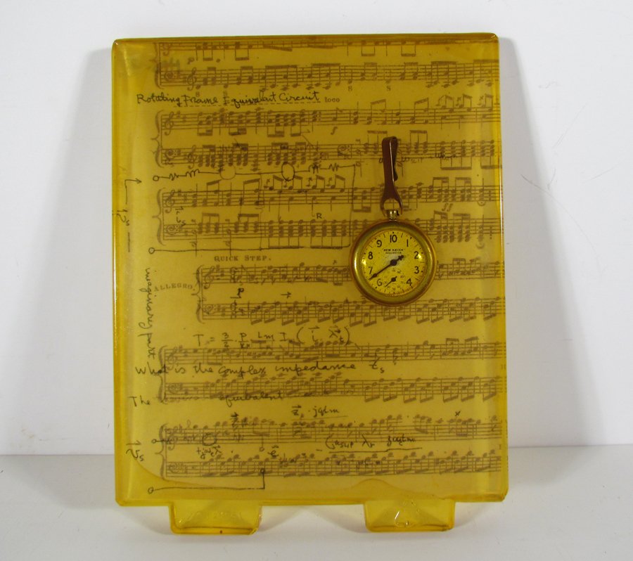 Adrienne Heinrich Sheet Music and Pocket Watch Cast: Artist: Heinrich, Adrienne (Contemporary American) Title: Untitled (Sheet Music and Pocket Watch) Medium: Cast Silicone with Inclusions Dimensions: 10.25 x 8 x .5 inches Provenance: acquired fro