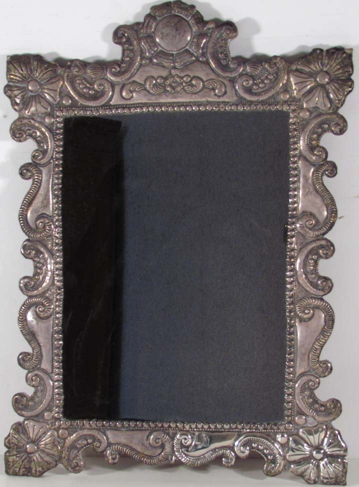 silver Embossed dressing mirror w wood backing: Title: Early 20th Century Silver Embossed Dressing Mirror with wood easel backing Date: early 20th Century Medium: mirror embossed silver and wood Dimensions: 25 x 17 1/2 x 1/2 inches
