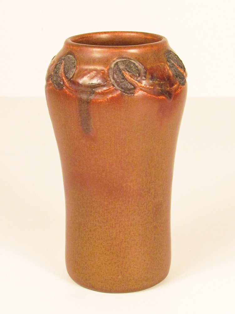 Rookwood Brown Vase 935E by Charles Todd: Title: Charles Todd glazed Rookwood Vase With Poppies in low relief around the neck Dimensions: 6.75 inches tall Signature: with Rookwood stamp and C.S.T. initials and 935E on underside