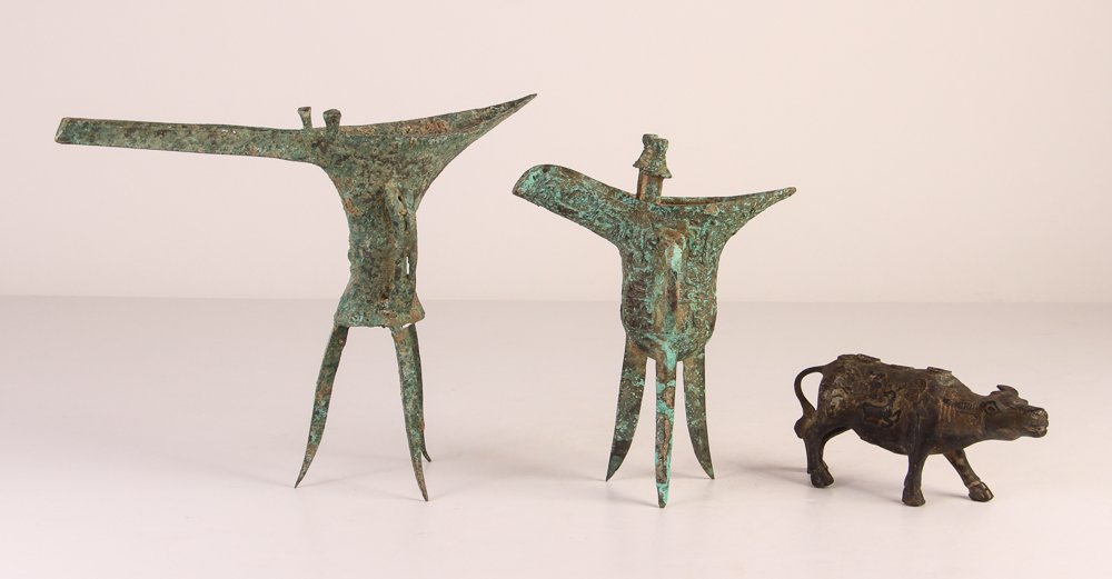 Zhu and Ming Style Vessels With Buffalo: Title: Two Archaic Style Bronze Tri-Footed Wine Vessels in Zhu and Ming Style and Water Buffalo With Buddhist Symbols Medium: Bronze Dimensions: Large Vessel: 8.75 x 12 x 2.5, Buffalo: 3 x 2 x 6.25 in