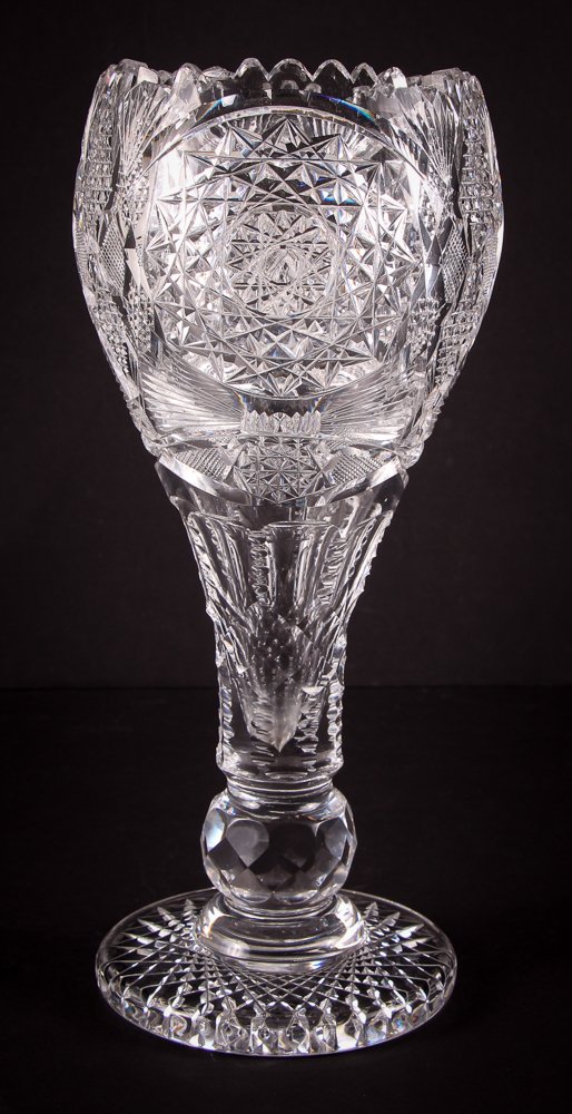 Brilliant Cut Glass Tulip Vase: American circa 1895, 14.25 inches tall, upon a plain round base which is cut with crosshatching surmounted by a faceted ball. The stem supported bowl is faced with three panels with diamond pointed ro