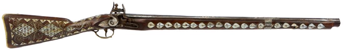 ANTIQUE INDIAN FLINTLOCK MUSKET WITH MOP INLAY: ANTIQUE INDIAN FLINTLOCK MUSKET WITH MOP INLAY Floral engraved lockplate. Floral high relief on barrel. Mother of Pearl and silver inlay throughout wood stock. Brass trigger, trigger guard, and buttpl