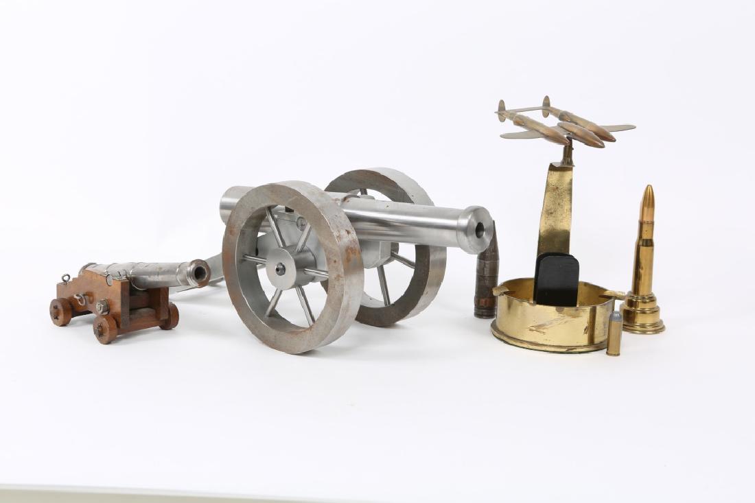 WWII US TRENCH ART & CANNON LOT: WWII US TRENCH ART & CANNON LOT WWII US trench art & cannon lot. Includes 1- p-38 ashtray trench art, 2- small metal cannons (large barrel measures 12", small barrel measures 7", and more. Size: 12"