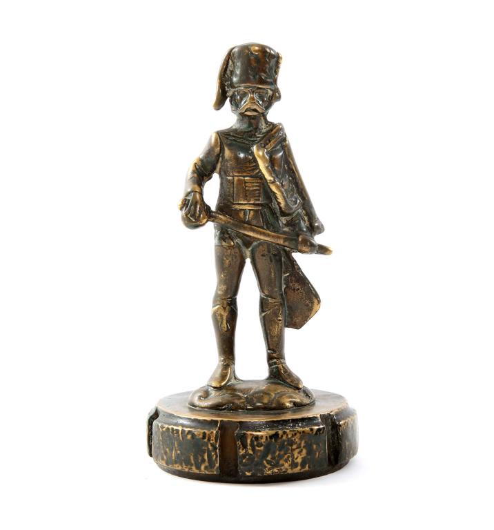 ANTIQUE AUTOMOBILE RADIATOR CAP FIGURE: ANTIQUE AUTOMOBILE RADIATOR CAP FIGURE An early and unusual 20th century bronze car mascot with attached, threaded radiator cap, depicting a Hussar, possibly British, German or French in dress uniform
