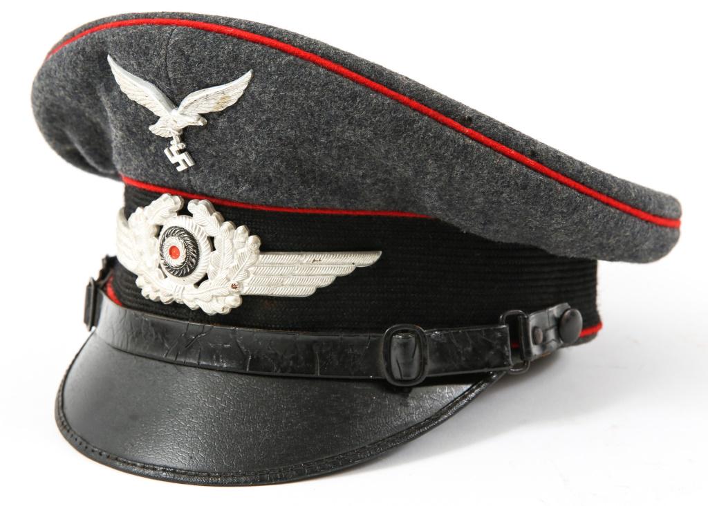 WWII GERMAN LUFTWAFFE NCO VISOR HAT: WWII GERMAN LUFTWAFFE NCO VISOR HAT WWII German Luftwaffe NCO visor hat. Gray / blue wool fabric with red piping, aluminum eagle badge and wreath cockade, Mfg Clemens Wagner, dated 1937. Size: 56