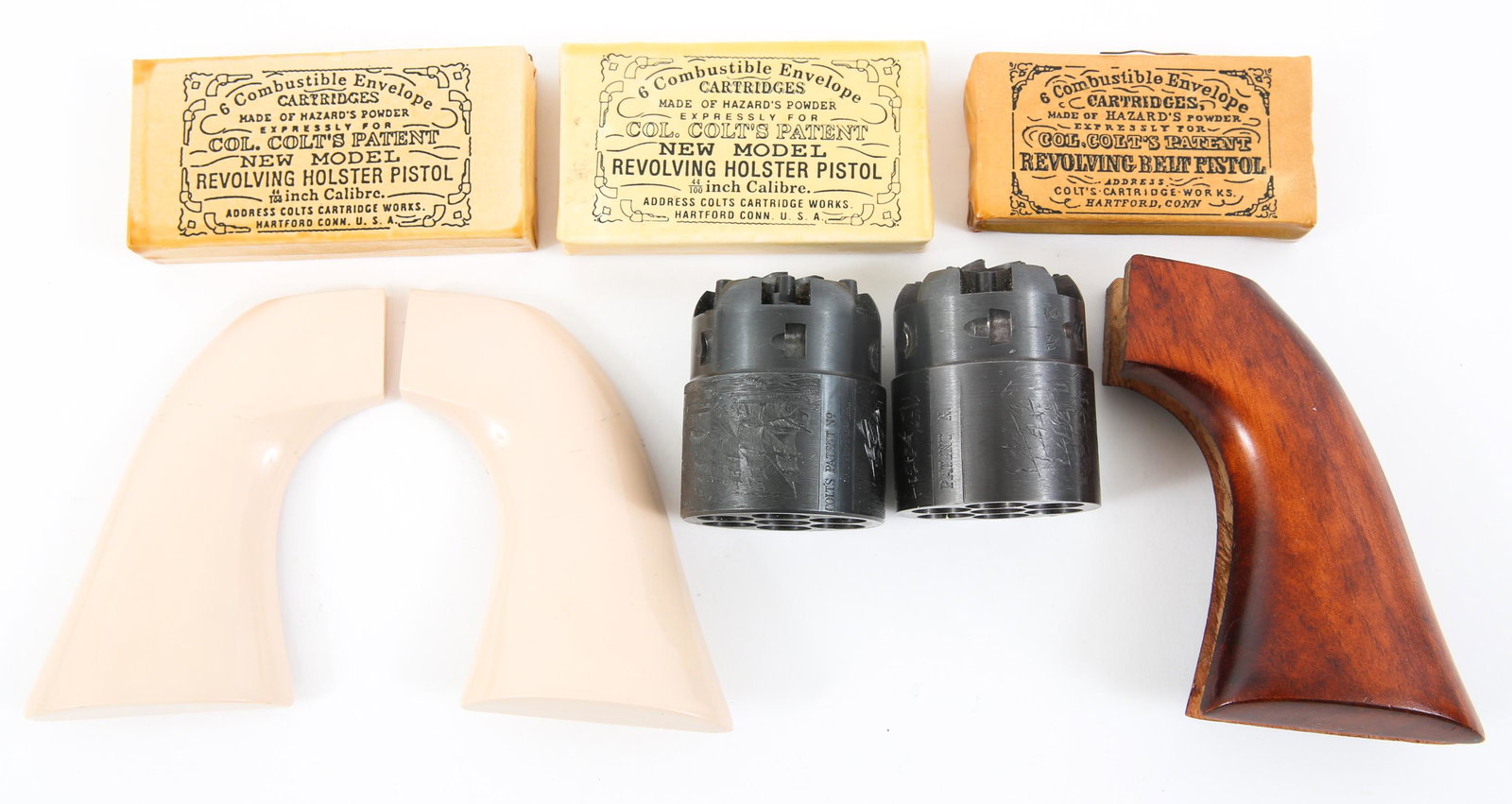 PERCUSSION REVOLVER POWDER CYLINDERS & GRIPS LOT: PERCUSSION REVOLVER POWDER CYLINDERS & GRIPS LOT Lot of 1850 percussion revolver reproduction parts, lot includes : (3) inert packages of 6 combustible envelope skin cartridges made of Hazard's Powder
