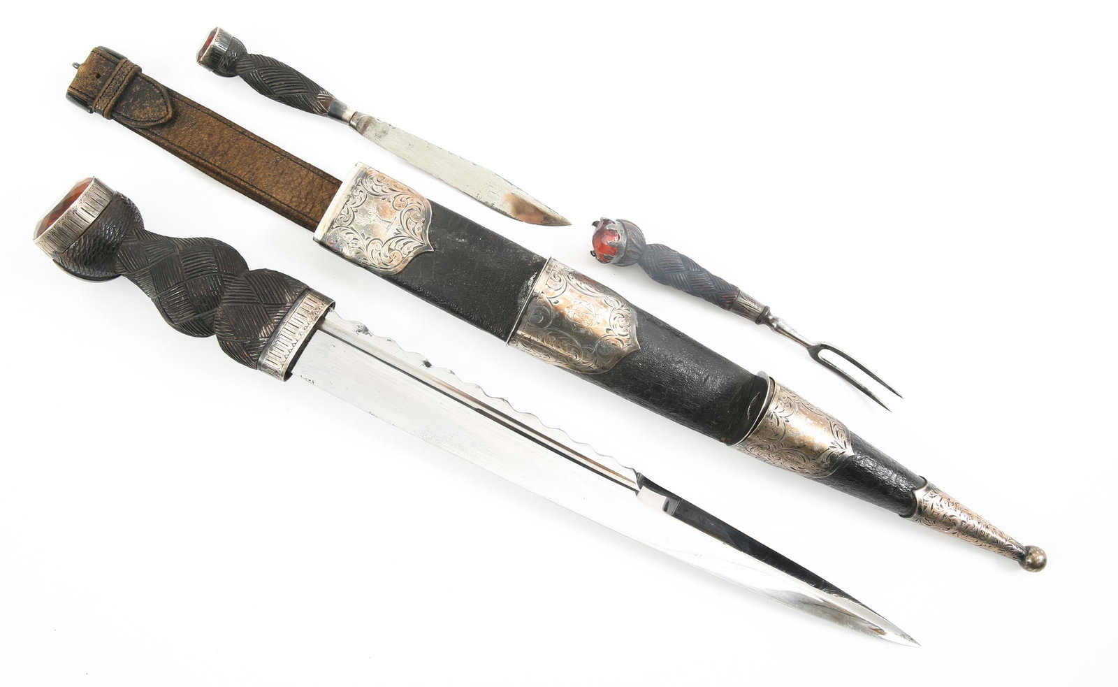 SCOTTISH HIGHLAND MARKED DIRK KNIFE: SCOTTISH HIGHLAND MARKED DIRK KNIFE SET Early 20th Century gilt knife set with scabbard. Circular Citrine mounted pommels, etched bog wood handle with black leather covered scabbard. Etched woven patt