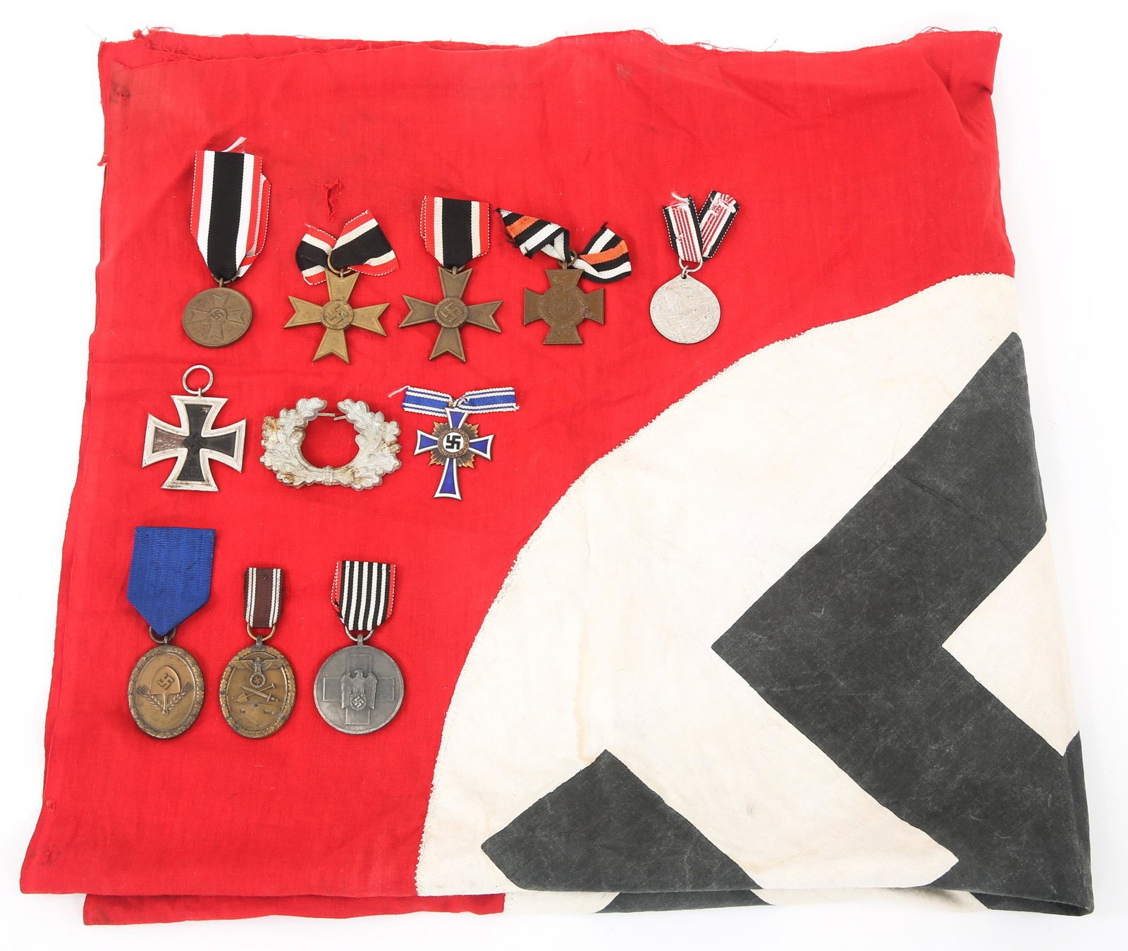 WWII GERMAN MEDALS & FLAG LOT: WWII GERMAN MEDALS & FLAG LOT Lot of Pre WWII & WWII German Medals. Includes: Flag, Pre-WWI Boxer Rebellion Campaign Medal. WWII German Iron Cross 2nd Class (Maker Marked "3" on ring), West Wall Medal