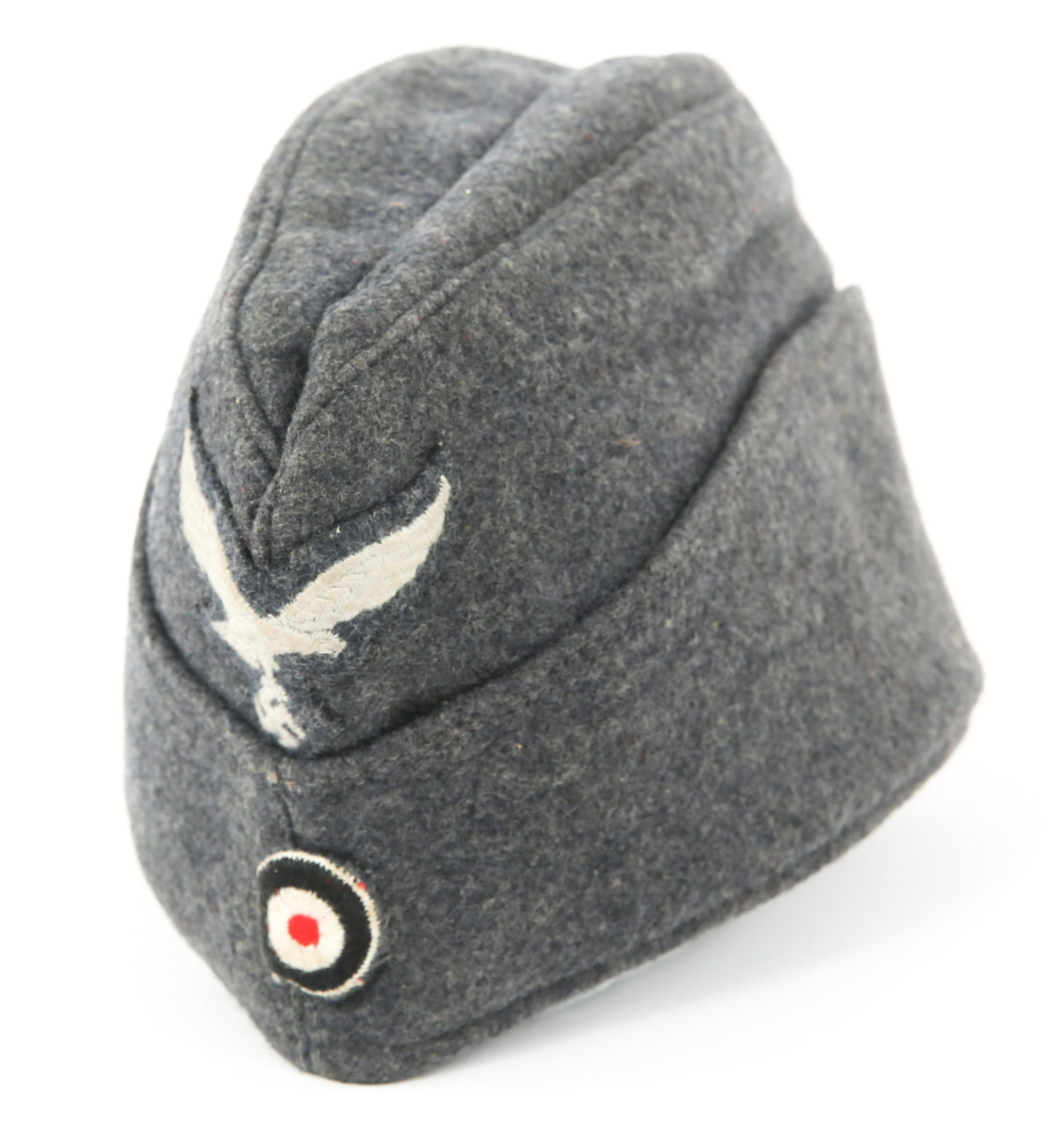 WWII GERMAN LUFTWAFFE OVERSEAS CAP: WWII GERMAN LUFTWAFFE OVERSEAS CAP WWII German Luftwaffe Overseas Cap. Blue / gray wool with Luftwaffe insignia above embroidered rosette. Inside of cap is marked "1942" below illegible stamped marks.