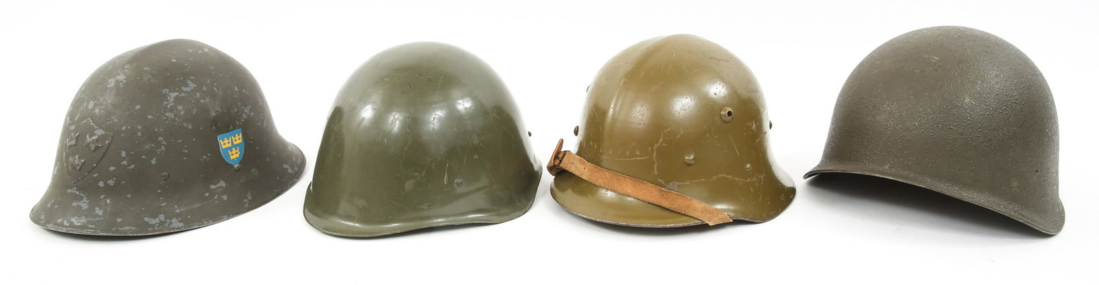 WORLD MILITARY HELMETS LOT OF 4: WORLD MILITARY HELMETS LOT OF 4 World military helmets lot of 4. (1) Swedish Model 21 steel helmet, frontal and side decal. 3-finger liner. (1) Swiss Model 71 helmet, liner & chinstrap. (1) Hungarian 