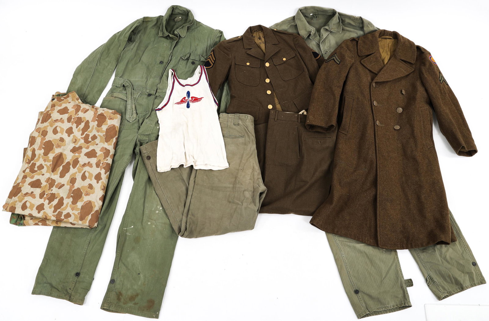WWII US ARMY HBT COVERALLS & UNIFORMS LOT: WWII US ARMY HBT COVERALLS & UNIFORMS LOT WWII US Army Uniforms lot. (1) WWII US Army 5th Infantry 4 pockets tunic & trousers 31 x 30, dated 45. (1) WWII Wool overcoat with 106th Infantry Division sho