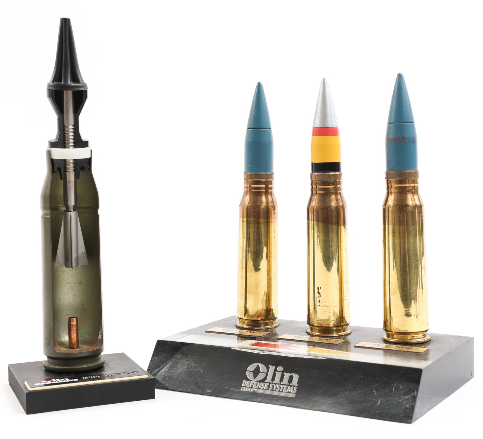 1980'S OLIN DEFENSE SYSTEM DISPLAY PLAQUES: 1980'S OLIN DEFENSE SYSTEM DISPLAY PLAQUES Olin Defense Systems Group display lot includes: (1) 20mm PGU-28, PGU-28, PGU-30 round desk display, inert. (1) M919 APFSDS-T 25mm round, display plaque, ine