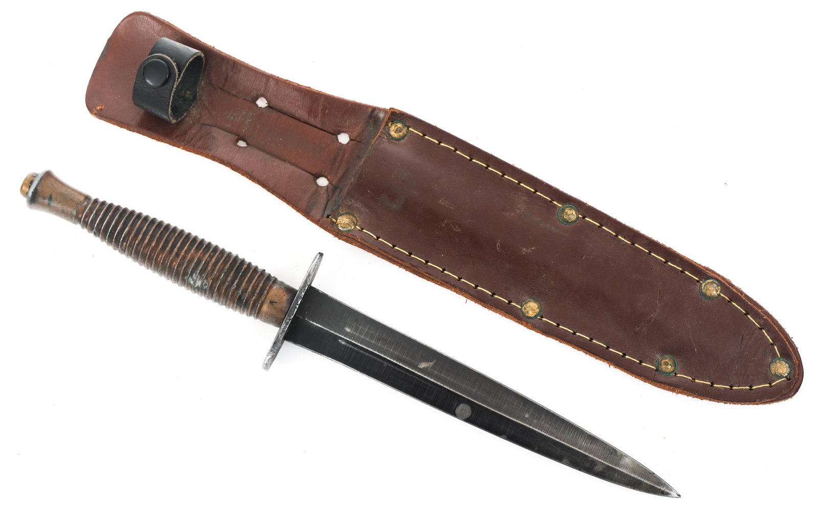 WWII BRITISH FAIRBAIRN COMANDO KNIFE & SHEATH: WWII BRITISH FAIRBAIRN COMANDO KNIFE & SHEATH WWII British command Fairbairn knife. Parkerized blade and crossguard, "Sheffield England" marked on crossguard. Brass ridged grip with "v" on it. Leather
