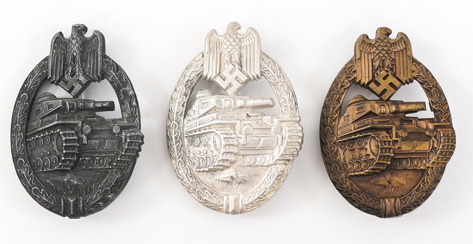 WWII GERMAN ARMY PANZER BADGE LOT OF 3: WWII GERMAN ARMY PANZER BADGE LOT OF 3 Lot of 3 WWII German Panzer Badges. (2) WWII German Army Panzer badges in Silver Grade. Both unmarked. (1) WWII German Army Panzer Badge in Bronze Grade. Maker m
