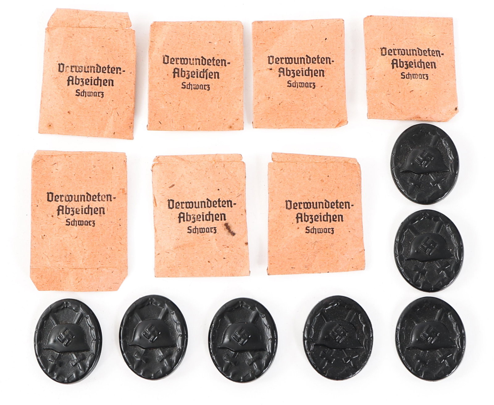 WWII GERMAN BLACK WOUND BADGE W/ POUCH LOT OF 7: WWII GERMAN BLACK WOUND BADGE W/ POUCH LOT OF 7 Lot of 7 WWII German Black Wound Badges with Original Paper Pouches. Black painted and lacquered steel construction. Maker marked "107" for Carl Wild. I
