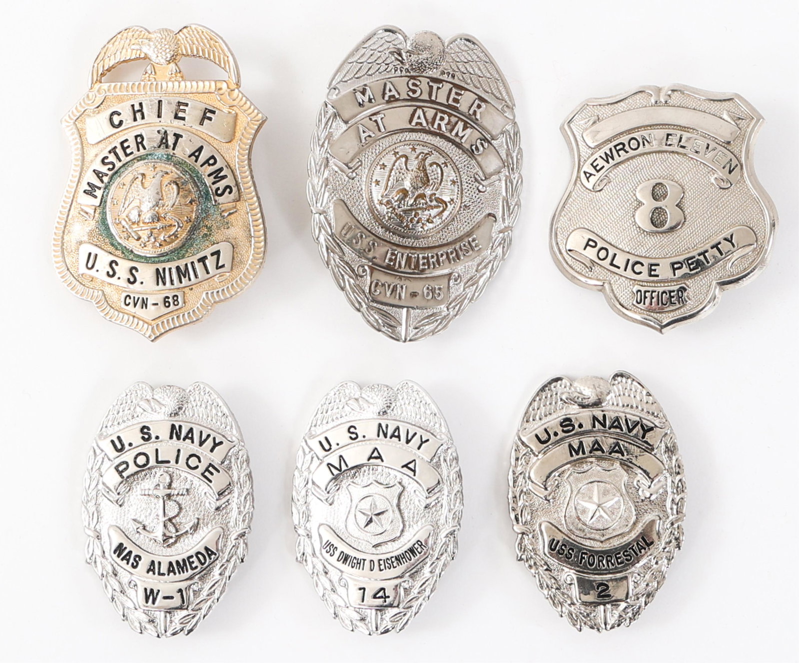 US NAVY MASTER-AT-ARMS & POLICE BADGES LOT OF 6: US NAVY MASTER-AT-ARMS & POLICE BADGES LOT OF 6 Lot of 6 WWII - Cold War US Navy Badges. (1) U.S.S Nimitz CVN-68, Chief Master-At-Arms gilded Badge. Serial number removed from the back. Size: 2" x 3".