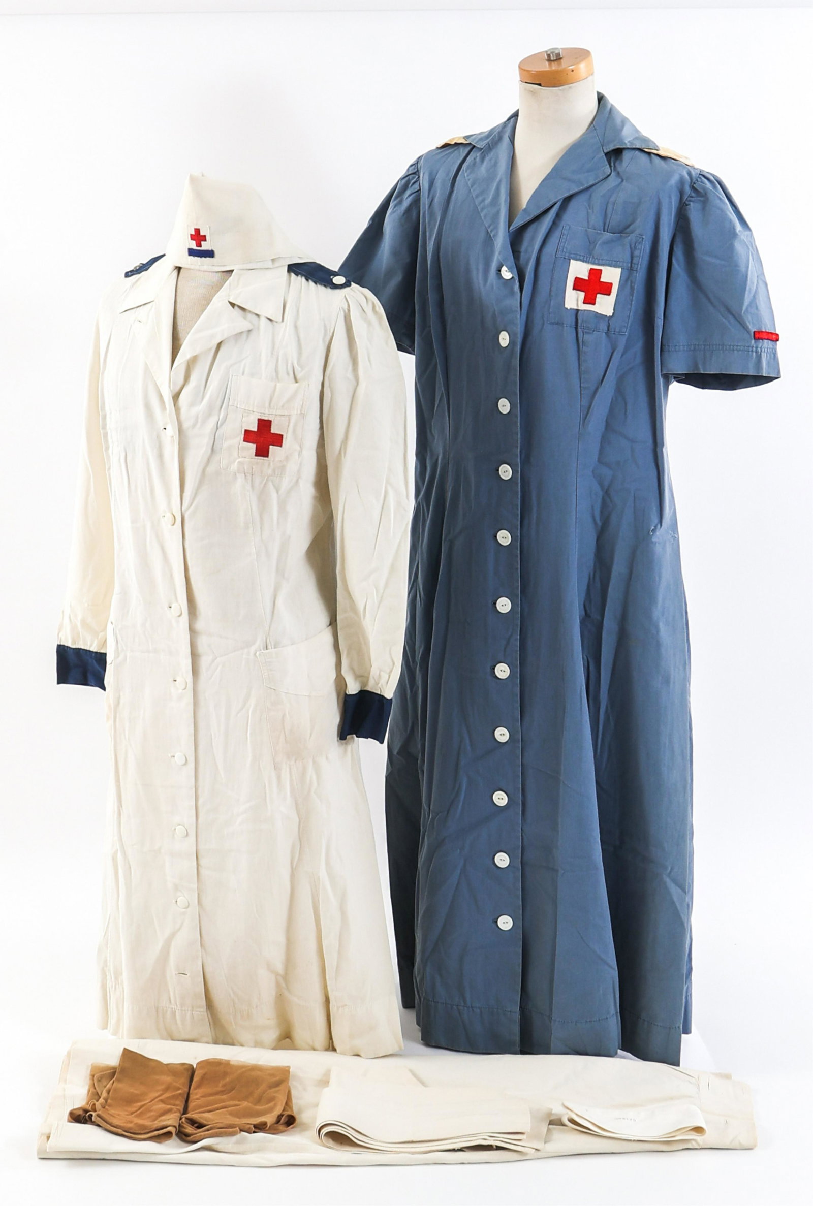 WWII ERA AMERICAN RED CROSS FEMALE UNIFORMS: WWII ERA AMERICAN RED CROSS FEMALE UNIFORMS WWII Era American Red Cross Female Working Uniforms. (1) ARC Production Branch Uniform. White cotton dress with red cross chest patch, dark blue epaulettes 