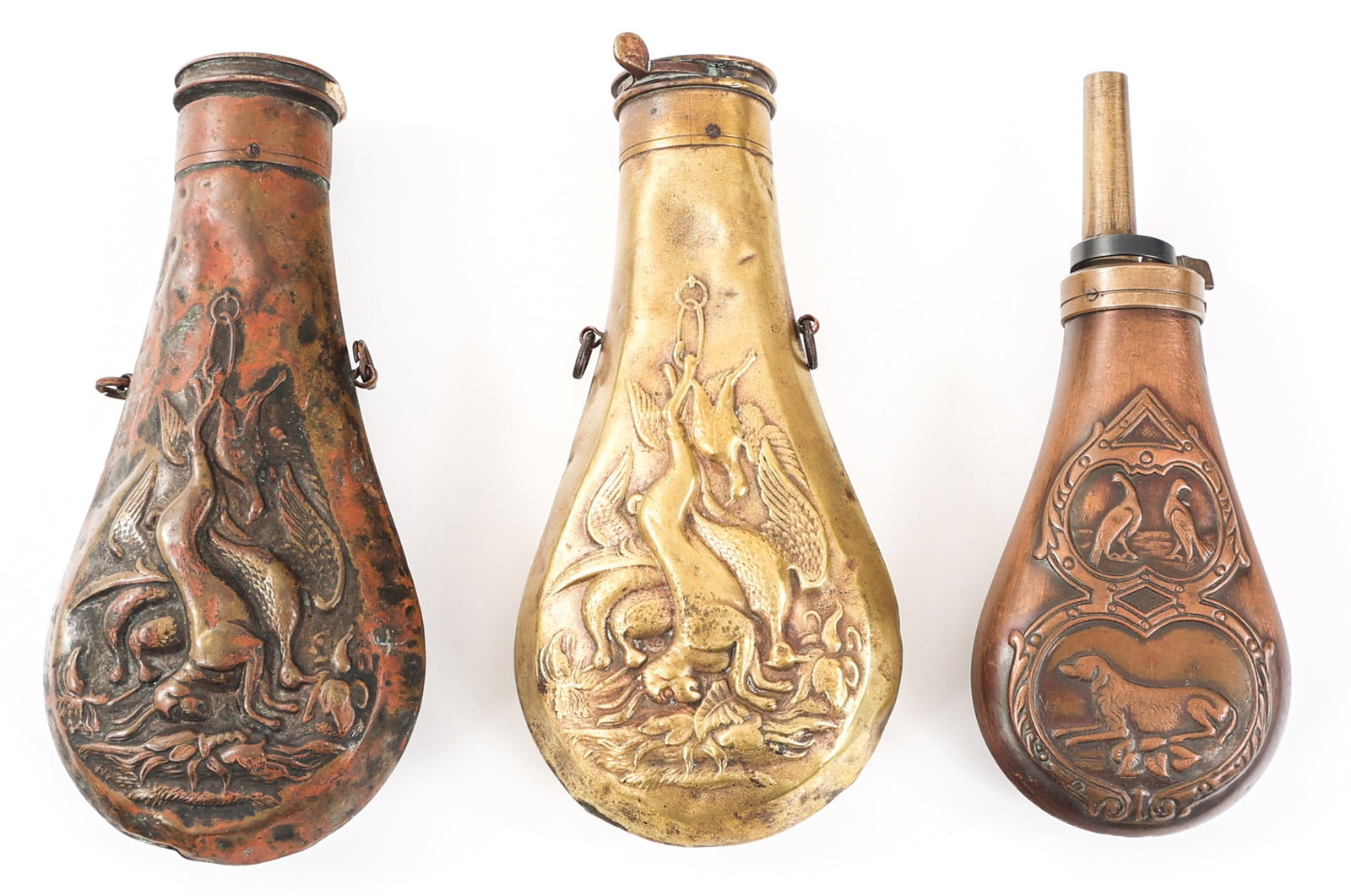 19th C. - CURRENT BRASS POWDER FLASK LOT OF 3: 19th C. - CURRENT BRASS POWDER FLASK LOT OF 3 Lot of 3 19th C. - Current Brass Powder Flasks. (2) 19th C. decorated brass powder flasks. Both are maker marked by American Flask & Cap Co. and are missi