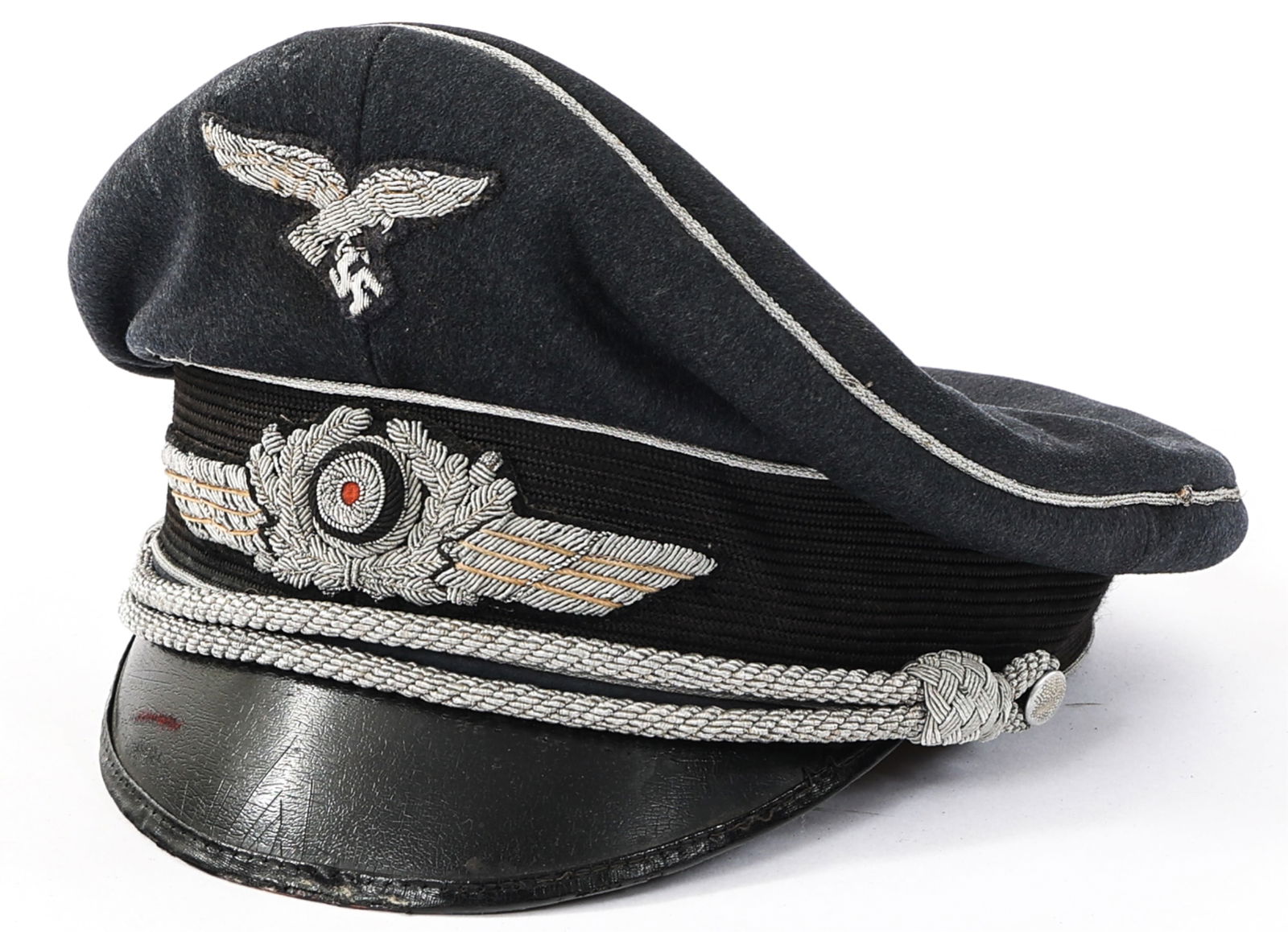 WWII GERMAN LUFTWAFFE OFFICER VISOR CAP: WWII GERMAN LUFTWAFFE OFFICER VISOR CAP WWII German Luftwaffe Officer Visor Cap. Blue-grey wool construction with silver piping. Bullion Luftwaffe eagle cap badge and wreathed cockade. Silver thread c